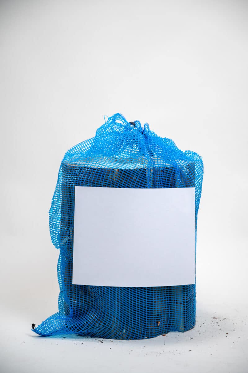 A blue bag with a white sign reading "Firewood 24/7" displayed prominently on the front.