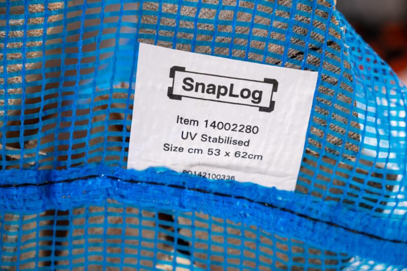 A blue mesh bag labeled "Firewood 24/7" displayed in a blank portrait view.