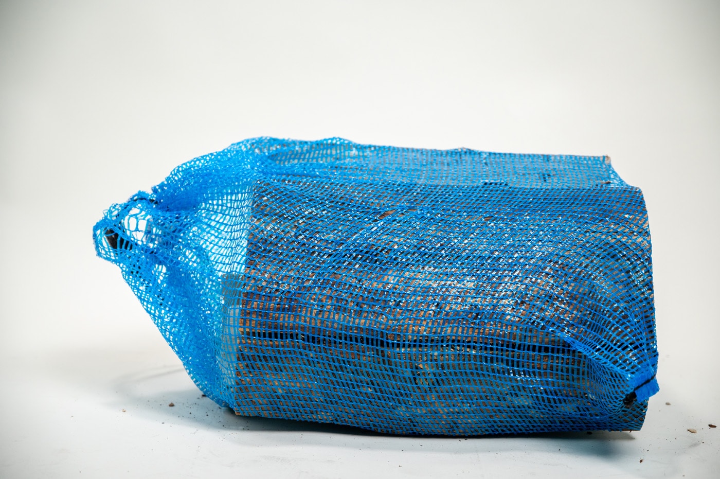 A blue bag with a handle displayed horizontally on a white background, labeled "Firewood 24/7."