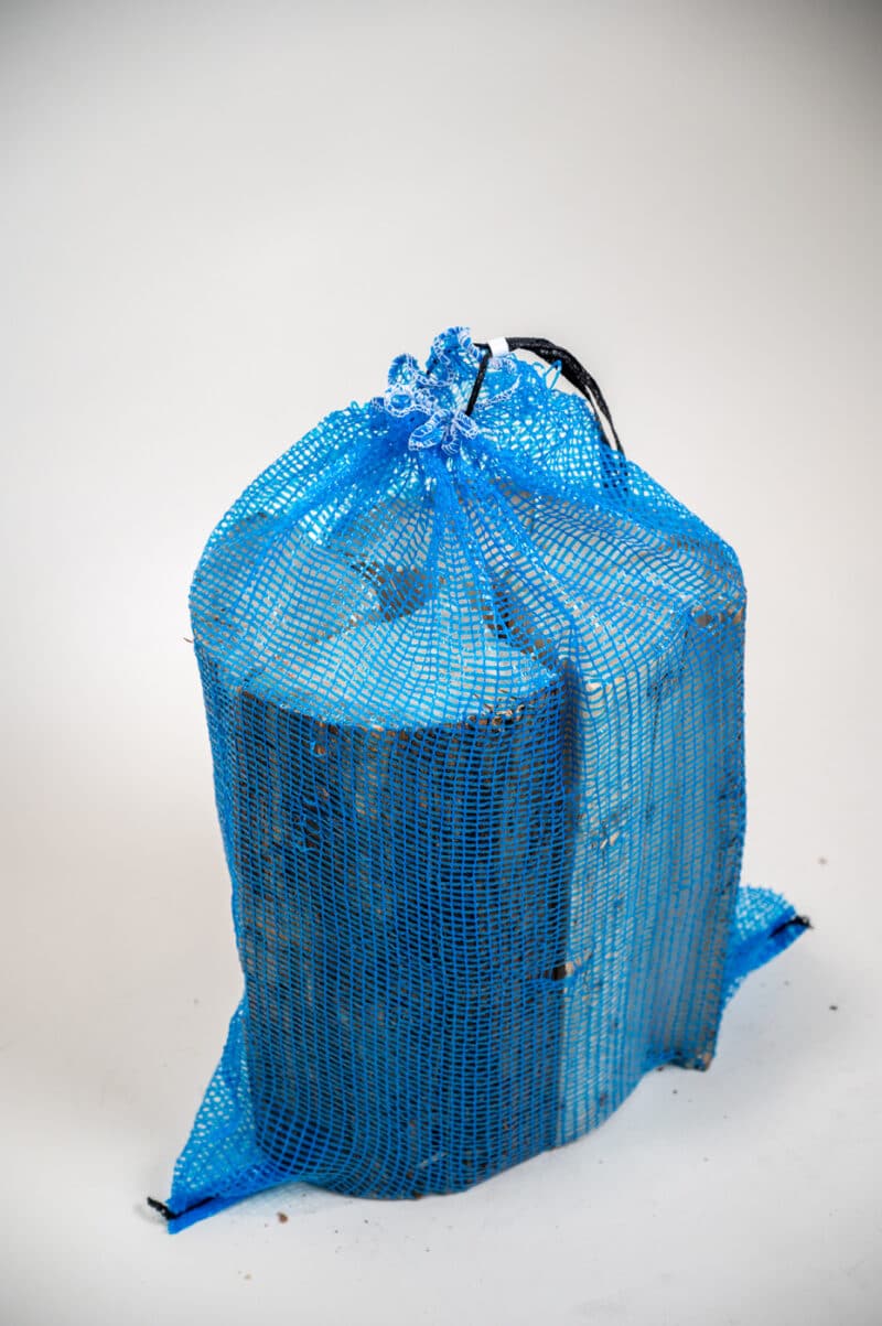 A blue bag with a handle on a white background, labeled "Firewood 24/7 - Blue Bag Top Side."