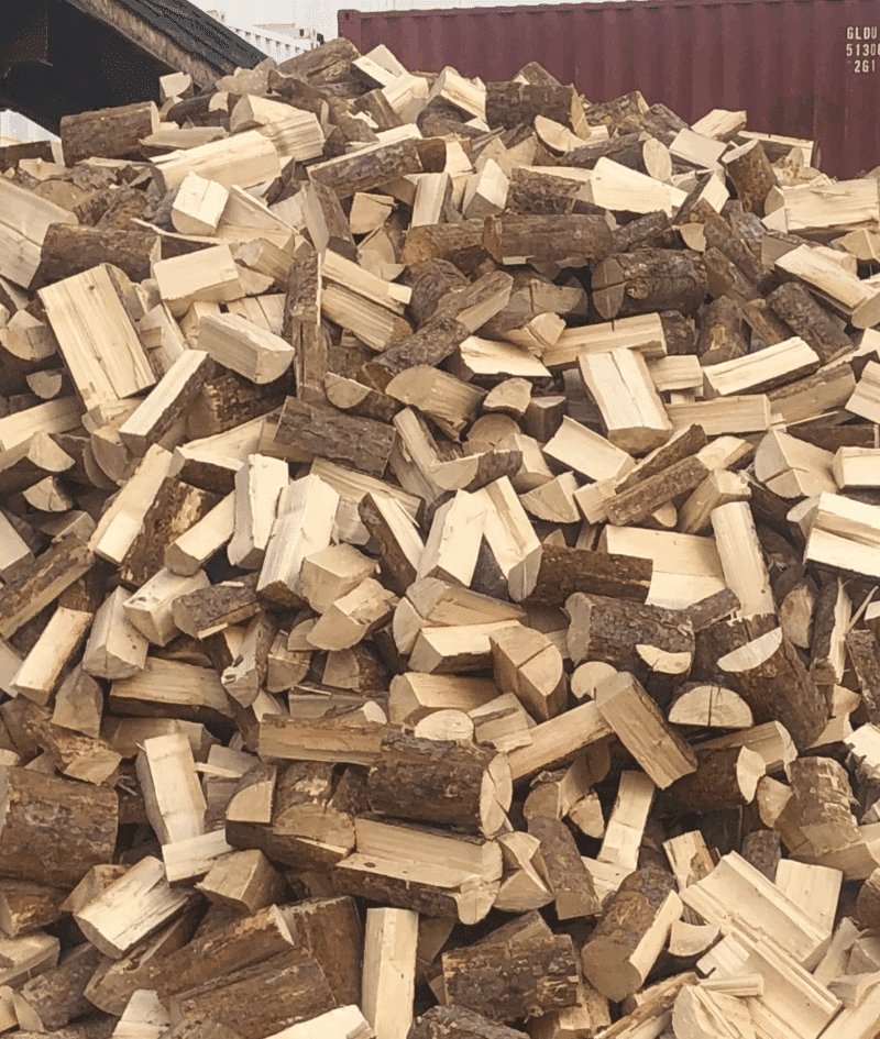 Pile of pine firewood stacked neatly, available for purchase 24/7, showcasing its natural texture and color.