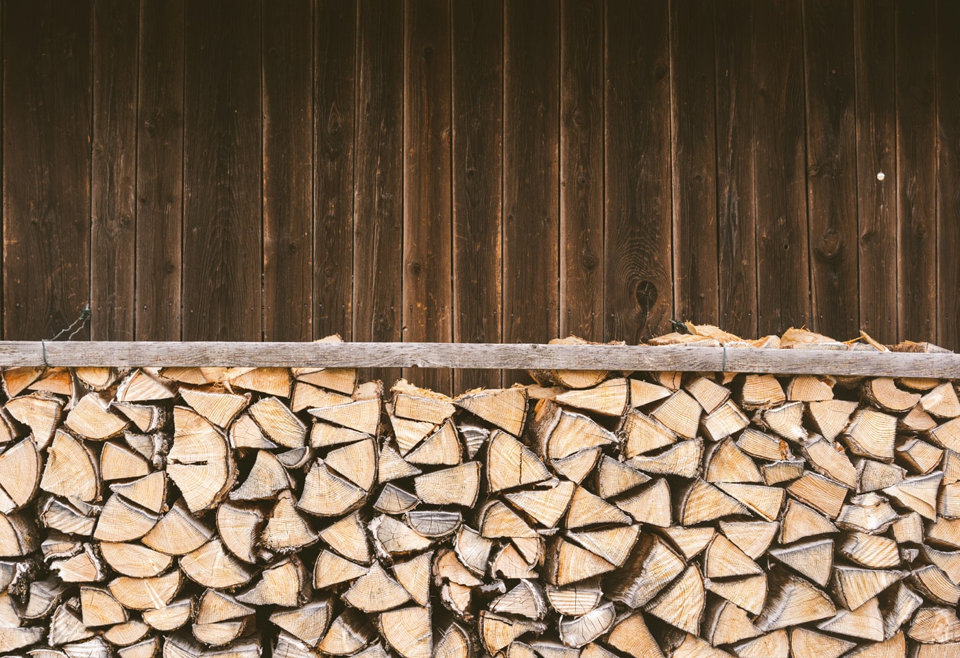 Stacked pile of firewood, ready for use, showcasing various sizes of logs in a neat arrangement.