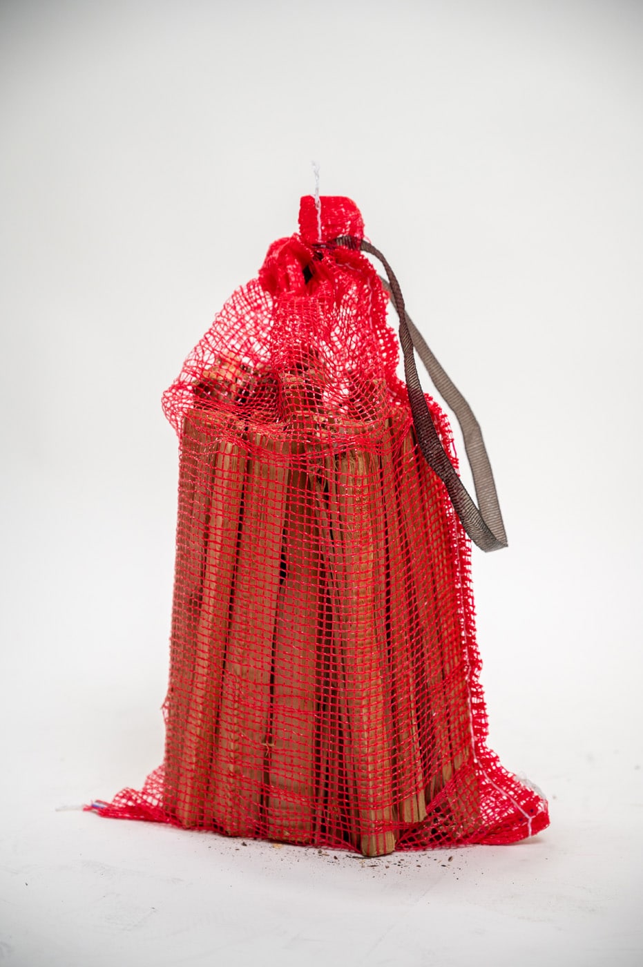 A red bag of firewood sticks displayed on a white background, labeled "Firewood 24/7."