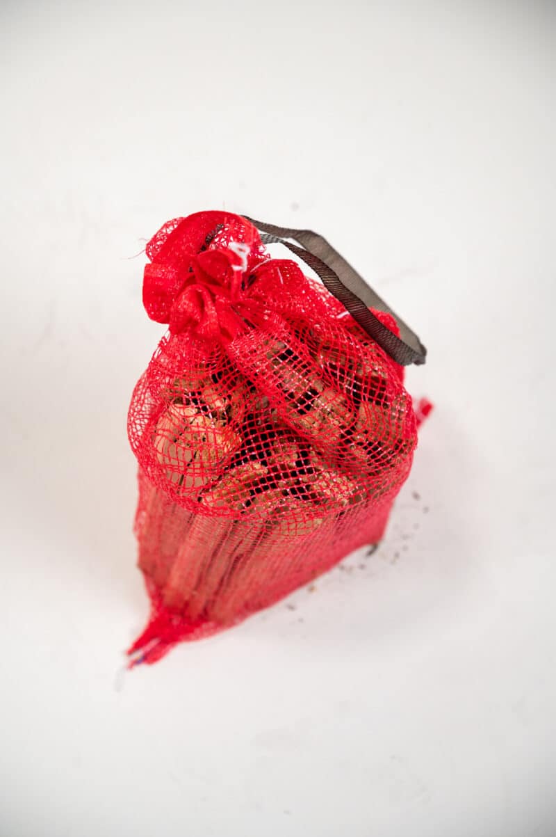A red bag containing a small piece of cake, labeled "Firewood 24/7 - Red Bag Top Wide."