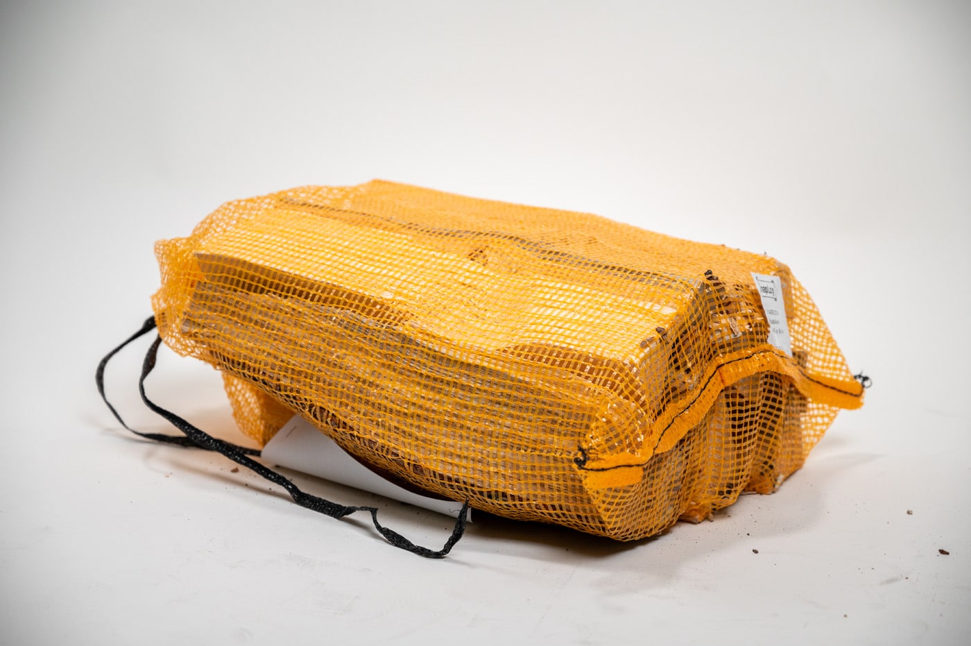 Yellow bag with a zipper, labeled "Firewood 24/7," viewed from the top right angle.